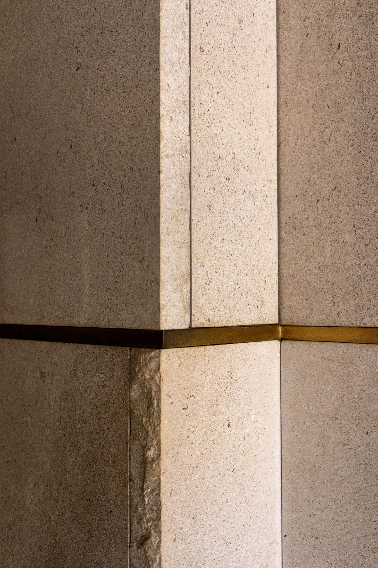 Venetian plaster, stone, and brass junction photographed on site