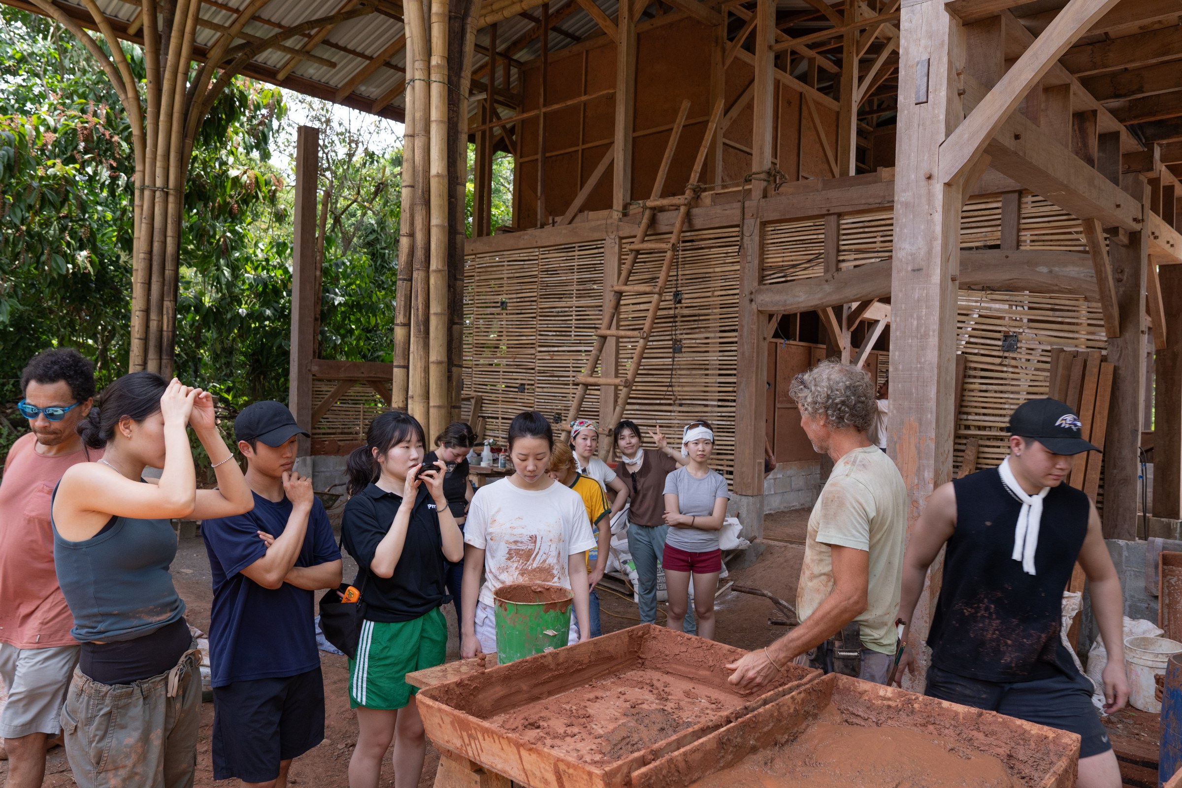 Students gathered around an earthen material workshop